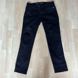 Svarta jeans från Replay - Snygga svarta jeans från Replay Hyperflex Anbass med dragkedja och knappstängning. De har en klassisk femficksdesign och en stilren look. Perfekta för en stilren och bekväm outfit.