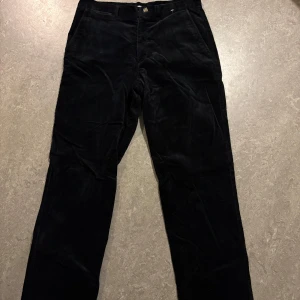 Svarta manchesterbyxor från Via Cortesa - Snygga svarta manchesterbyxor från Via Cortesa med knapp och dragkedja framtill. Byxorna har en klassisk design med en bekväm passform och randigt foder på insidan av midjan. Byxorna är i sprillansnytt skick.