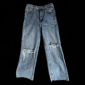 Blå jeans från Zara - säljer ett par blå jeans från Zara med slitna detaljer vid knäna. dom sitter mid waist, så dom stannar en bit under naveln. står storlek 38 och skulle säga att dom sitter precis som storleken säger, modellen är dock lite mer baggy av sig. priset går alltid att diskuteras! 💕