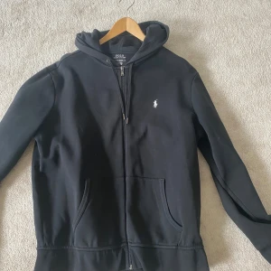 Ralph lauren zip hoodie - Svart Ralph Lauren hoodie strlk L. Använd fåtal gånger så bra skick, endast lite nopprigt på nedre delen av ryggen.