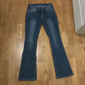 Blå bootcut jeans med broderade fickor - Snygga blå bootcut jeans med broderade detaljer på bakfickorna. Stretchiga och sköna men urvuxna 