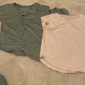 T-shirt i rosa och grön från SOC - Säljer tre tränings t-shirts från SOC i mjukt material. En i ljusrosa och två i grön. Perfekta för en avslappnad stil eller träning. De har en rund hals och korta ärmar.