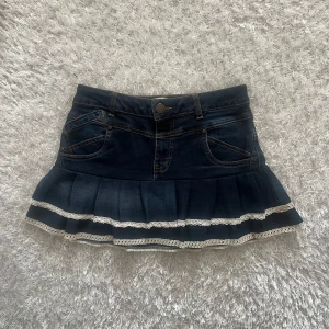 Lågmidjad jeanskjol - En lågmidjad jeanskjol omsydd från ett par jeans. Midjemått tvärsöver - 36cm Längd - 32cm