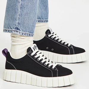 Svarta sneakers från Eytys - Snygga svarta sneakers från Eytys i modellen Odessa med en chunky vit sula och vita snören. Skorna har en lila flik baktill och kontrasterande vita sömmar som ger en cool look. Perfekta för en trendig stil.