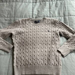 Stickad Ralph Lauren tröja - Säljer en väldigt snygg grå Ralph Lauren tröja. Den är i väldigt bra skick utan några fel alls. ✅Använd ett fåtal gånger. Tröjan borde passa xs-s då det ör 14-16 år i barnstorlek📐. Skriv till mig vid frågor och funderingar så svarar jag så snabbt jag kan😊