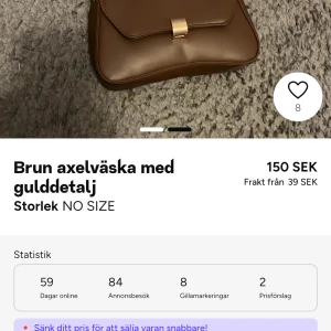Brun axelväska med gulddetalj - Snygg brun axelväska med elegant gulddetalj på framsidan. Perfekt för att ge en stilren touch till din outfit. Väskan har en praktisk storlek och är lätt att bära med sig.