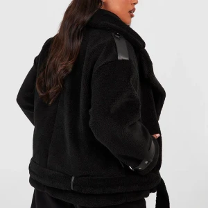 Svart teddyjacka/pilotjacka - Snygg svart teddyjacka med bältesdetaljer på ärmarna och axlarna. Jackan har en oversized passform och är perfekt för kyligare dagar nu till våren!💖