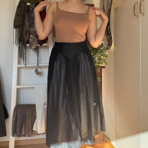 Svart långkjol - VINTAGE! Köpt secondhand och endast använd ett fåtal gånger. Snygg svart långkjol med en elegant och enkel design. Kjolen har en normal passform och är perfekt för olika tillfällen. Den är tillverkad i ett lätt och bekvämt material som ger en fin siluett.