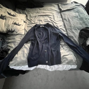 Mörkblå kofta från Pier One - Säljer en stilren mörkblå kofta från Pier One. Koftan har långa ärmar och knappar framtill, perfekt för lager-på-lager-stil. Passar bra till både jeans och kjol. Perfekt för kyliga dagar!