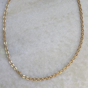 Guldfärgat extra långt armband - Elegant guldfärgat armband med små, runda länkar. Perfekt för att lägga till en subtil touch av elegans till din stil. Armbandet har ett klassiskt lås som gör det enkelt att ta på och av. Låset är silverfärgat. Längd ca 27 cm