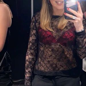 Svart spetsblus - Säljer en elegant svart spetsblus med långärmad design. Perfekt för en kväll ute eller en speciell tillställning. Blusen har ett transparent mönster som ger en sofistikerad look.
