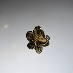 Guldfärgad blomformad ring - Säljer en elegant guldfärgad ring med en vacker blomformad design. Ringen har detaljerade blomblad som ger en stilren och sofistikerad look. 💖