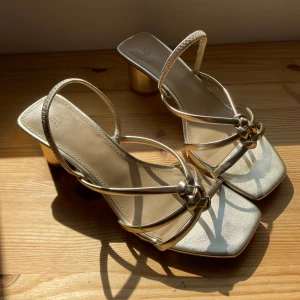 Guldiga klackskor stl.36/37 - Guldiga klackskor från HM. Använda en kväll. Nypris: 299kr. Stl.36 men passar mig som har stl.37. 