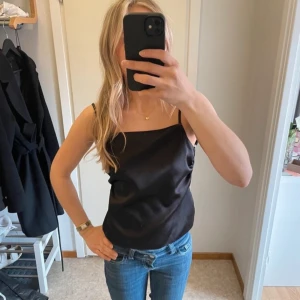 svart satinlinne - Snyggt svart linne i satin med smala axelband. Skulle säga att den passar M! Använd en gång, skriv för fler bilder!!