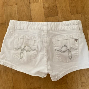 Jeansshorts  - Super snygga vita low waist jeansshorts med silverdetaljer från Guess💋Är helt oanvända och är i nyskick!
