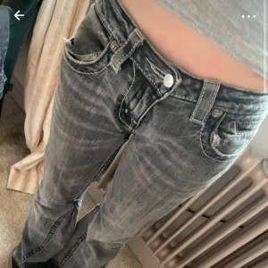 Svarta miss me jeans med detaljer - Snygga svarta jeans från Miss Me med unika detaljer på bakfickorna. Jeansen har en låg midja och en bootcut-stil. De är omsydda men det syns inte. Jag har köpt de för 2000 och använt de ungefär 3 gånger. Jag säljer de på Vinted också! 