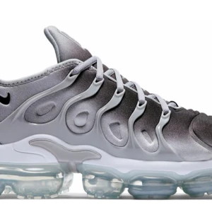 Nike Air Vapormax Plus i grått - Snygga Nike Air Vapormax Plus sneakers i en stilren grå färg. Skorna har en unik design med synliga luftkuddar i sulan för extra komfort och en futuristisk look. Perfekta för både träning och vardagsbruk. Köpta för 2200 Kr
