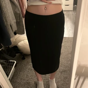 Svart kjol från H&M - Säljer en stilren svart kjol från H&M i storlek M. Kjolen har en enkel design och är tillverkad i bomull med lite elastan för extra komfort. Perfekt för en minimalistisk look. sitter mer som en xs