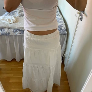 Vit långkjol - Säljer en vit långkjol med elastisk midja. Kjolen har en luftig och flödande design med flera lager som ger en fin volym. Perfekt för varma dagar och kan enkelt matchas med olika toppar. Nästan som nyskick och säljer för 120kr💕går att pruta! Har du tyvärr klippt bort lappen så minns inte var kjolen är ifrån. Kjolen är inte strykt på första bilderna men kolla sista bilden för att se hur den ser ut när den är strykt!💕