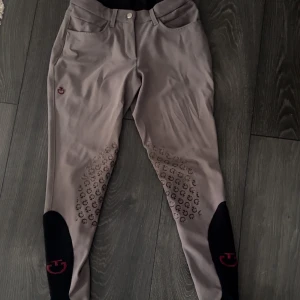 Cavalleria Toscana ridbyxor  - Halvskodda/knäskodda ridbyxor från Cavalleria Toscana. Mörkbeige (mullvad), storlek IT 38 = svensk 34, normala i storleken. Använt skick men hela, professionell lagning av skräddare i sömmen (se näst sista bilden). Något missvisande ljus på vissa bilder, de är mörkare - första två samt sista bilden visar ”rätt” färg.  Älskar dessa men de är tyvärr för små för mig.  Nypris 2800kr.