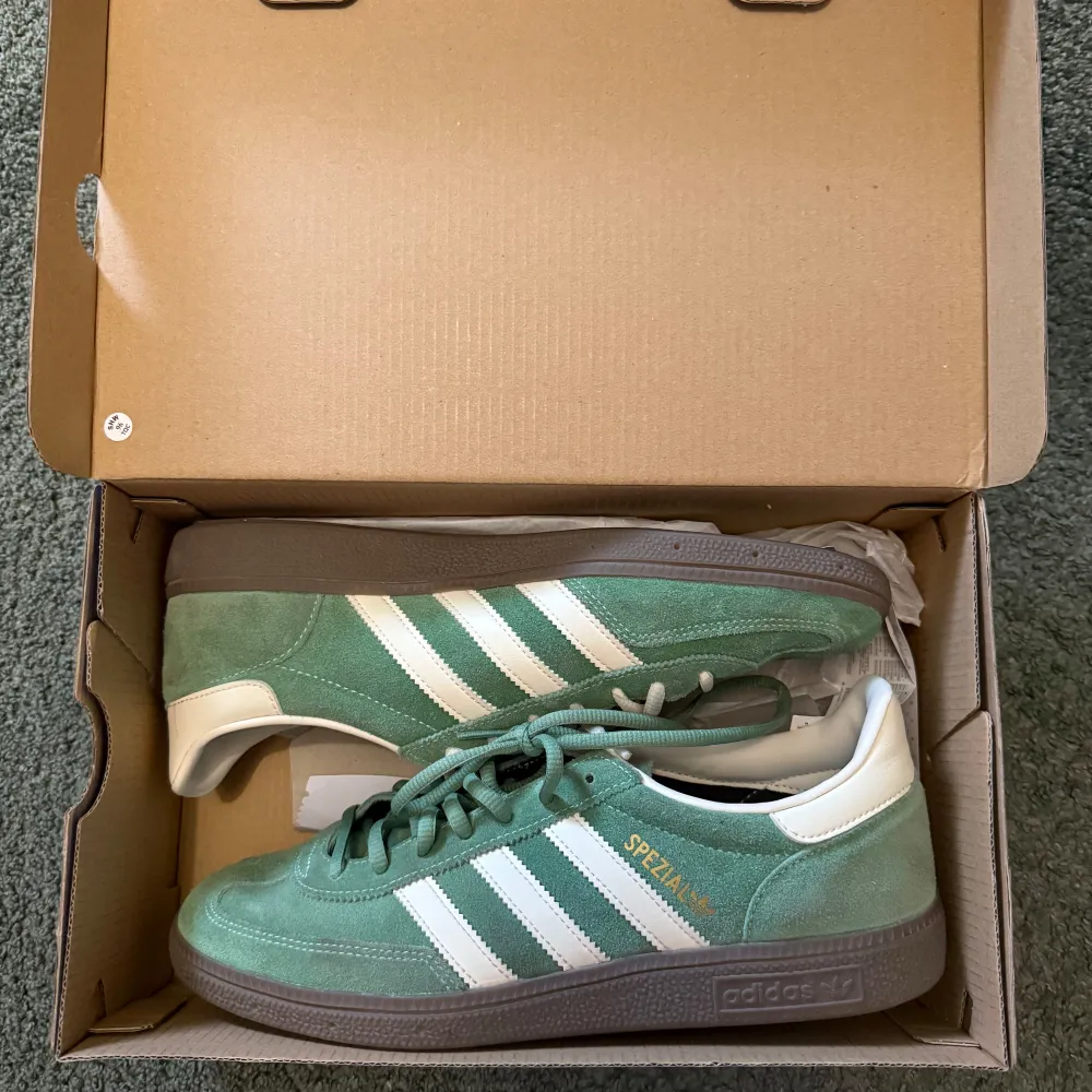 Snygga gröna Adidas Spezial sneakers med vita detaljer och klassiska tre ränder på sidan, som en ny. Perfekt för sommaren.. Kengät.