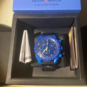 Omega x swatch mission to Neptune  - Säljer en Omega Speedmaster MoonSwatch i en snygg blå färg. Klockan har en biokeramisk konstruktion och en tydlig tachymeter-skala på ringen. Den har en klassisk design med tre sub-dials och en svart urtavla. Perfekt för den som älskar stil och funktionalitet. Box ingår och original papper följer också med.