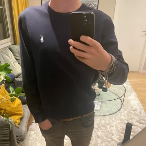 Mörkblå tröja från Ralph Lauren - Tjena ! Säljer nu en stilren mörkblå tröja från Ralph Lauren med det klassiska logotypbroderiet på bröstet. Tröjan har en rund halsringning och långa ärmar. Tröjan har inga skador eller defekter. Kontakta för fler frågor eller bilder🙌