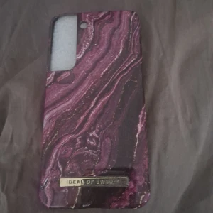 Mobilskal från Ideal of Sweden - Snyggt mobilskal från Ideal of Sweden med ett marmorerat mönster i lila och rosa nyanser. Skalet har en elegant design med en glansig yta.  Ursprungligt pris: 199 kr.