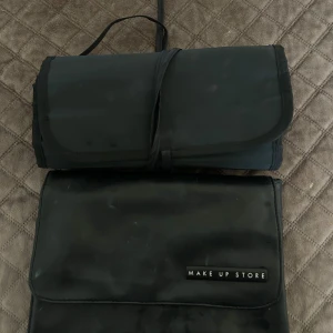 Svart sminkväska från Make Up Store - Praktisk svart sminkväska från Make Up Store med flera fack och dragkedjor. Perfekt för att organisera sminkborstar och andra sminkprodukter. Väskan är hopfällbar och lätt att ta med sig.