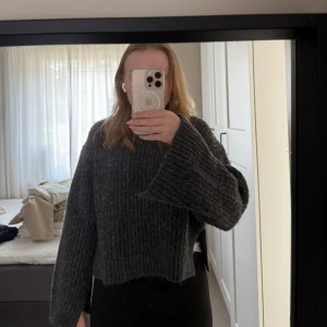 Grå ribbad stickad tröja från Gina Tricot - Säljer en mysig grå stickad tröja från Gina Tricot. Tröjan har en ribbad design med långa ärmar med slita armen och i sidan av tröjan. Perfekt för alla dagar. Tröjan är använd fåtal gånger. 