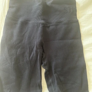 STRONGER shorts - Snygga svarta ribbade cykelbyxor från STRONGER med hög midja. Perfekta för all typ av träning. De har en elastisk passform som ger bra stöd och komfort. Inga tecken på användning!