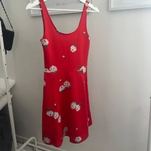 Blommig sommarklänning  - Gullig röd sommarklänning med blommor på 🌸 Använd fåtal gånger, jättefint skick. Skriv meddelande vid frågor/fler bilder 🩷