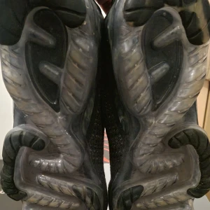 Nike Vapormax sneakers - Snygga Nike Vapormax sneakers i svart med stickad ovandel och unik sula. Skorna har en modern design med detaljer som 'LOCK' på hälen och en futuristisk look. Perfekta för den som vill ha både stil och komfort. Utan låda 