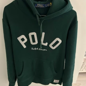 Grön hoodie från Ralph Lauren - Säljer en snygg grön hoodie från Ralph Lauren med stor POLO-logga på framsidan. Nypris ca 2500kr. Hög kvalitet med få användningar, bra skick!