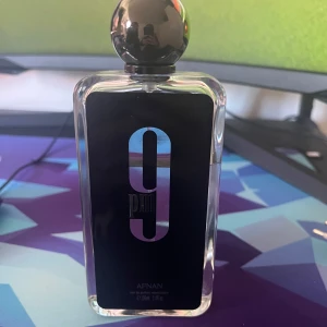 9 PM Parfym från Afnan - Säljer en elegant parfymflaska från Afnan, 9 PM, med en stilren svart design och en rundad kork. Doften har noter av vanilj, amber och varm krydda, med inslag av frukt, kanel och lavendel. Perfekt för den som söker en söt och aromatisk upplevelse. Går också att byta