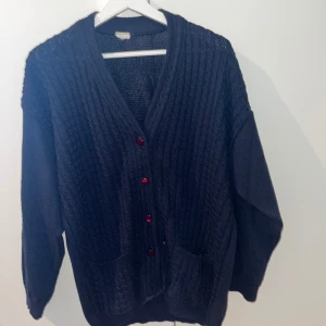 Cardigan - Säljer en stilren mörkblå cardigan med vinröda knappar. Den är märkeslös men har inget fel på sig nästan som helt ny. Perfekt för sommaren me en finare look.