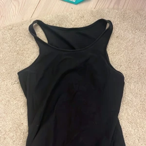 svart träningstopp💓 - Enkel och stilren svart linnetopp från Lindex i storlek 158/164. Toppen har smala axelband och rak halsringning🩷