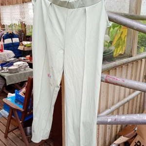 Ljusgröna kostymbyxor från H&M stl XL vida ben - Snygga ljusgröna kostymbyxor från H&M i rak modell. Byxorna har hög midja, pressveck och är gjorda i ett mjukt polyestertyg med lite elastan för extra komfort. Perfekta för en clean och stilren look., vida ben o stl XL