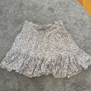 Beige blommig volangkjol - Blommig beige kjol från lager 157, använd några gånger och är i bra skick💞