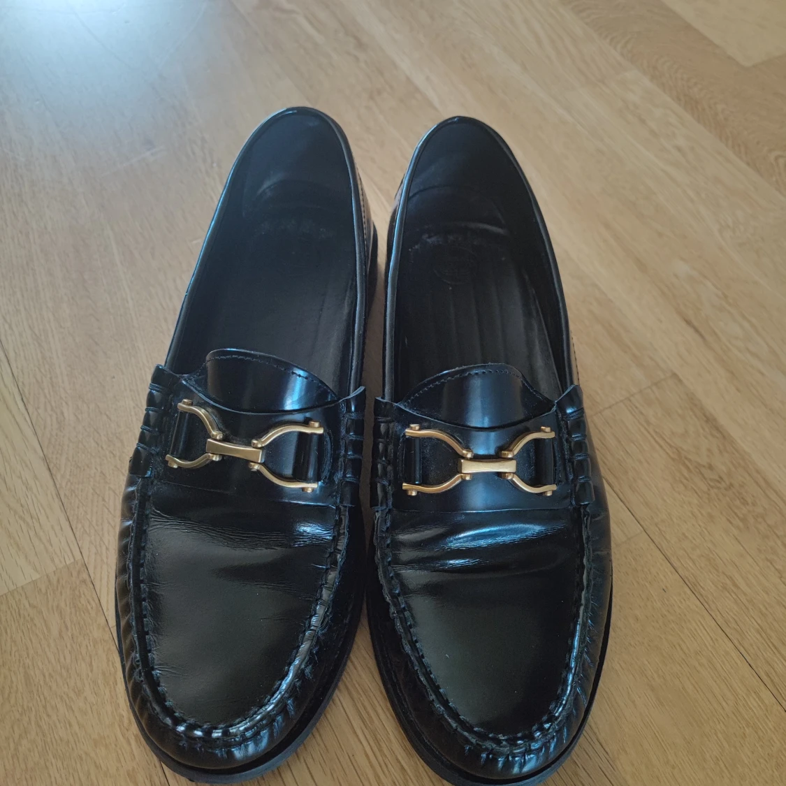Svarta loafers med gulddetalj
