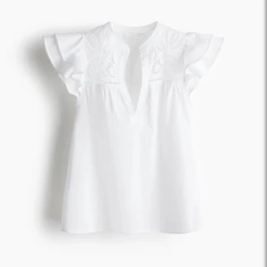 Vit blus med broderi från H&M - Superfin vit blus från H&M i bomull med broderade detaljer upptill och v-ringning. Blusen har korta, volangiga ärmar och en luftig passform. Perfekt för en fräsch och somrig look. Broderiet ger en extra touch och gör toppen unik. Den är stor i storleken så den passar mycket bra för storlek M.