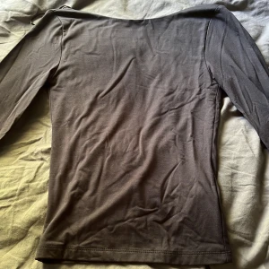 Gina tricot topp med öppen rygg - En mörk grå topp från Gina tricot med öppen rygg. Tröjan är i storlek XS och har sällan kommit till användning.