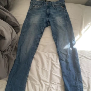 Replay ljusblå jeans, storlek 28/32 - Säljer ett par snygga ljusblå jeans från Replay i modellen Anbass. Jeansen har klassisk femficksdesign, raka ben och diskreta slitningar framtill. Materialet är mjukt denim med stretch för extra komfort. Perfekta för en avslappnad och trendig look.Dem är använda men dem ser helt nya ut☺️