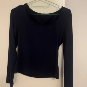 Svart långärmad topp med rund hals - En stilren svart långärmad topp med rundad halsringning. Enkel och lättmatchad modell som passar perfekt till jeans eller kjol. Tunn och mjuk i materialet för en bekväm känsla hela dagen.