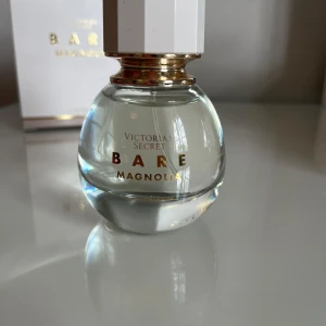 Victoria's Secret Bare Magnolia parfym - Fräsch och blommig parfym från Victoria's Secret, Bare Magnolia. Doften har inslag av magnolia, apelsinblomma och vaniljmusk. Volym: 50 ml. Knappt använd, se bild.