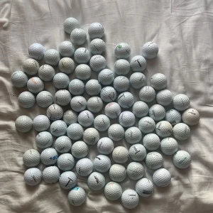 Golfbollar Titleist 80 stycken bra pris - Bilderna visar ett stort antal golfbollar av Titleist. Golfbollarna är använda och vissa har märken eller fläckar. Perfekt för dig som vill träna golf utan att lägga mycket pengar på nya bollar. Får köpas styck viss 5kr 