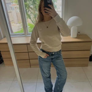 Beige sweatshirt från Acne Studios - Säljer en stilren beige sweatshirt från Acne Studios med klassisk rund hals och diskret logopatch på bröstet. Tröjan har lång ärm, ribbade muddar och är i mjuk bomull. Perfekt för en clean och avslappnad look.