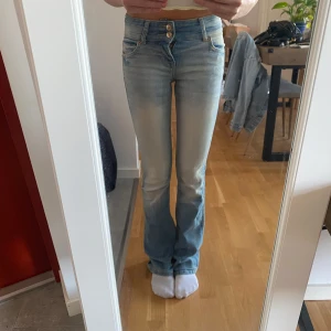 Lågmidjade jeans  - Lågmidjade jeans med två knappar och fin dimension med färgen 