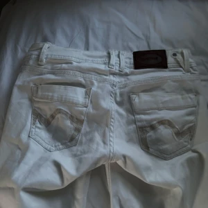 Vita jeansbyxor från Promod - Snygga vita jeansbyxor från promod med gulddetaljer på fickorna. Dom var straight men klippte en slit i dom så dom ser mer bootcut ut. Säljer pga att dom är alldeles för långa för mig som är 166 cm💕strl S