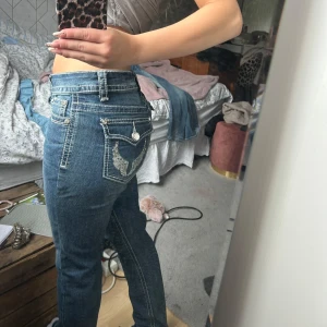Papaya jeans - Säljer ett par blå papaya jeans med ikoniska broderade bakfickor och vita kontrastsömmar. Jeansen har låg midja, raka ben och klassisk femficksdesign. Snygga detaljer med knappar och ficklock bak. Jag är 155 så de är för långa för mig men kan passa någon som är 160-170💕